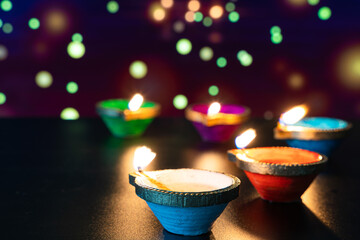 Wall Mural - Indian festival Diwali, Diya oil lamps lit on colorful rangoli. Hindu traditional. Happy Deepavali. Copy space for text.