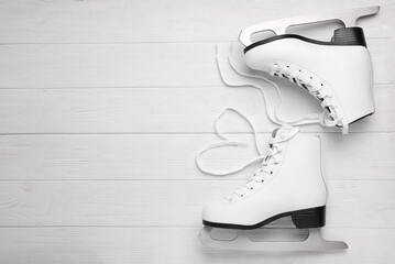 Wall Mural - pair of ice skates on white wooden background, top view. space for text