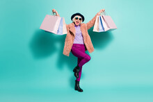 Photo Of Lucky Old Woman Dressed Vintage Outerwear Cap Eyewear Holding Bags Arms Up Isolated Turquoise Color Background