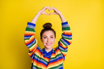 Poster - Photo of adorable young lady make hands look heart shape above head isolated on shine yellow color background