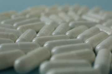 Wall Mural - White pills on blue background