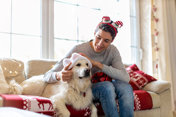 Canvas Print - Boy and his dog enjoying Christmas together at home 
