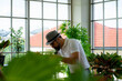 © ake - senior retired Caucasian man with smoking pipe doing indoor gardening in home greenhouse planting herb and green vegetable