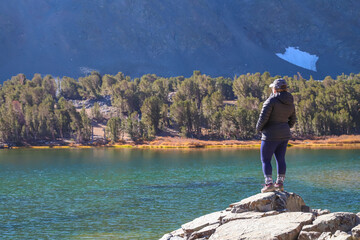 Wall Mural - MONO COUNTY, CALIFORNIA, UNITED STATES - Oct 17, 2020: Woman hiker standing at a lake