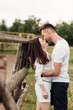 © Andriy Medvediuk - happy couple is kissing near wooden fence. young man and woman are having fun outdoors on a warm summer day.