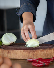 person slicing onion on kitchen board