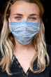 © Mint Images - Portrait of young blond woman wearing blue face mask.