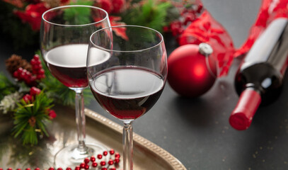 Christmas red wine glasses and xmas decoration on the table, closeup view