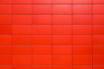 texture of the iron facade of an industrial building made of sheet metal panels with rivets, a close-up of the construction details painted in red with copy front view, nobody.