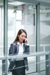 © JIACHUAN LIU/Stocksy - Businesswoman Using Cell Phone In Office Buildings