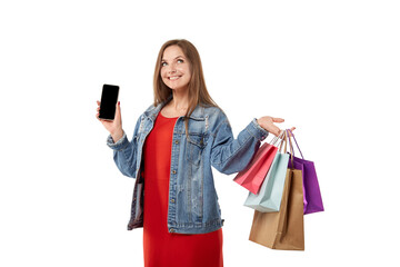 A young smiling woman is shopping online with a smartphone in her hands. Shopping online for gifts during the holidays. White isolated background.