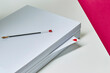 © French Anderson Ltd/Stocksy - A ream of white A4 paper sits on a desk with a love heart scribbled on a single page.