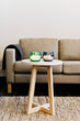 © Melissa Milis Photography/Stocksy - detail interior: beige sofa with small coffee table and two candles