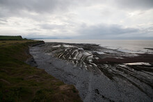 Rocky Beach Beneath Cliffs On The Bristol Channel With Cloud