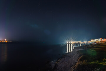 Wall Mural - Night nature landscape with sea coast and blue sky with stars.
