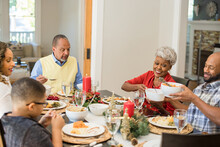 Black Family Eating Christmas Dinner Together At Dining Room Table