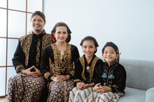 Portrait Of A Happy Family Wearing Traditional Javanese Clothes. Concept Of Family Photo Javanese Traditional Clothes In The Living Room