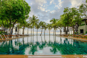 Wall Mural -  swimming pool with background of coconut tree and sea at beachfront resort