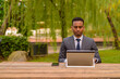 © Ranta Images - African businessman sitting outdoors using laptop computer