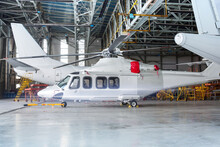 Passenger Helicopter And Airplanes Under Maintenance. Checking Mechanical Systems For Flight Operations. Rotorcraft And Aircrafts In The Hangar