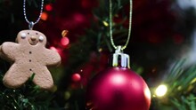 Ginger Bread Man Decoration On A Green Artificial Christmas Tree. Slider Shot.