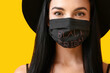 © Pixel-Shot - Beautiful young woman in medical mask on color background. Black Friday sale