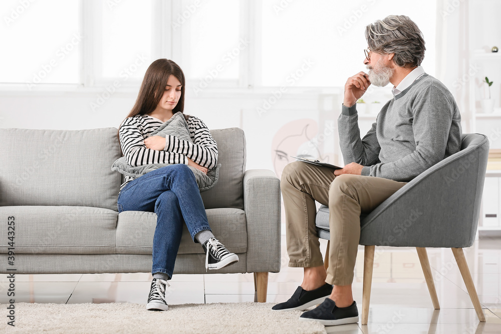 Male psychologist working with young girl in office