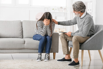 Canvas Print - Male psychologist working with young girl in office