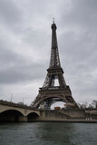 Fototapeta Paryż - The Eiffel Tower seen from the Seine on a cloudy morning. Paris, France.