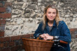 © Mint Images - Young blond woman on bicycle with basket, looking at camera.