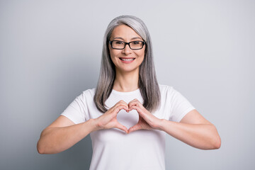 Poster - Photo of old woman demonstrate heart form look camera wear glasses white t-shirt isolated grey color background