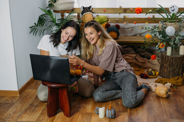 Thanksgiving online party, virtual dinner gathering. Holidays in the Time of COVID new normal, Pandemic time. Happy family, friends, two women celebrating Thanksgiving via internet near laptop