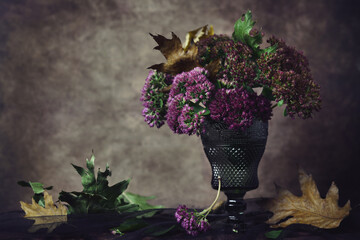 Wall Mural - pink autumn bouquet with dry leaves on dark background