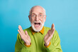 Photo of crazy retired granddad open mouth raise palms wear eyeglasses green pullover isolated blue color background