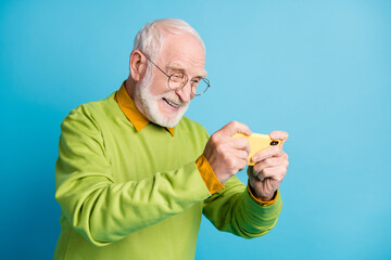 Sticker - Profile photo of excited grandpa hold cellphone cheerful smiling wear eyeglasses green sweater isolated blue color background