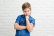 © yana_novak22 - boy 9-10 years old in a blue shirt on a light background, the emotion of resentment