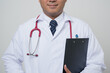 © Chanakon - Medium Close Up Physician in white coat, stethoscope holding clipboard to.beside arm and look into camera isolated on white background.