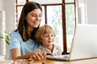 © Drobot Dean - Woman at home with her son using laptop computer