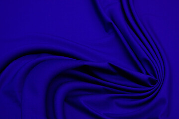 Wall Mural - Dark blue silk wavy fabric background, view from above. Smooth elegant blue silk or satin luxury cloth texture using as abstract background for design, close-up