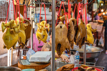 Boiled Chicken and Steamed duck hanging on the market stall in Old market downtown alley of Yaowarat Chinatown bangkok city Thailand.