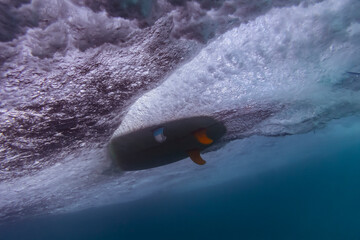 Under water view of wave, surfboard, underwater shot