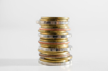 row of coin stack growing pile on white background for money saving and investment business financial and banking concept.