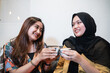 © Odua Images - young girls chatting and enjoy cup of coffee while sitting in a coffee shop