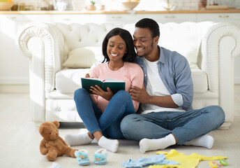 Preparing for childbirth. Pregnant black couple making checklist of baby things before going to maternity hospital