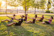 group of people practicing yoga outdoors. Pilates class in the park