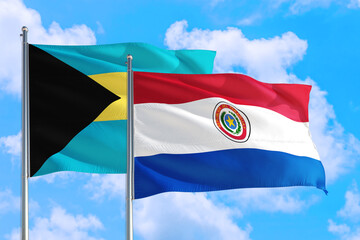 Paraguay and Bahamas national flag waving in the windy deep blue sky. Diplomacy and international relations concept.