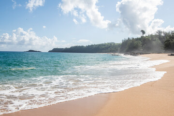 waves roll in on a quiet kauai north shore beach