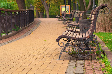 Picturesque morning landscape view of Volodymyr Hill after renovation. A lot of benches along cobblestone pathway. Blurred autumn colors in the background. Kyiv, Ukraine