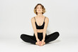 © SHOTPRIME STUDIO - Woman in leggings meditate in a light room with her legs crossed yoga asana