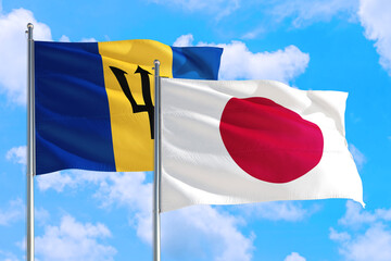 Wall Mural - Japan and Barbados national flag waving in the windy deep blue sky. Diplomacy and international relations concept.